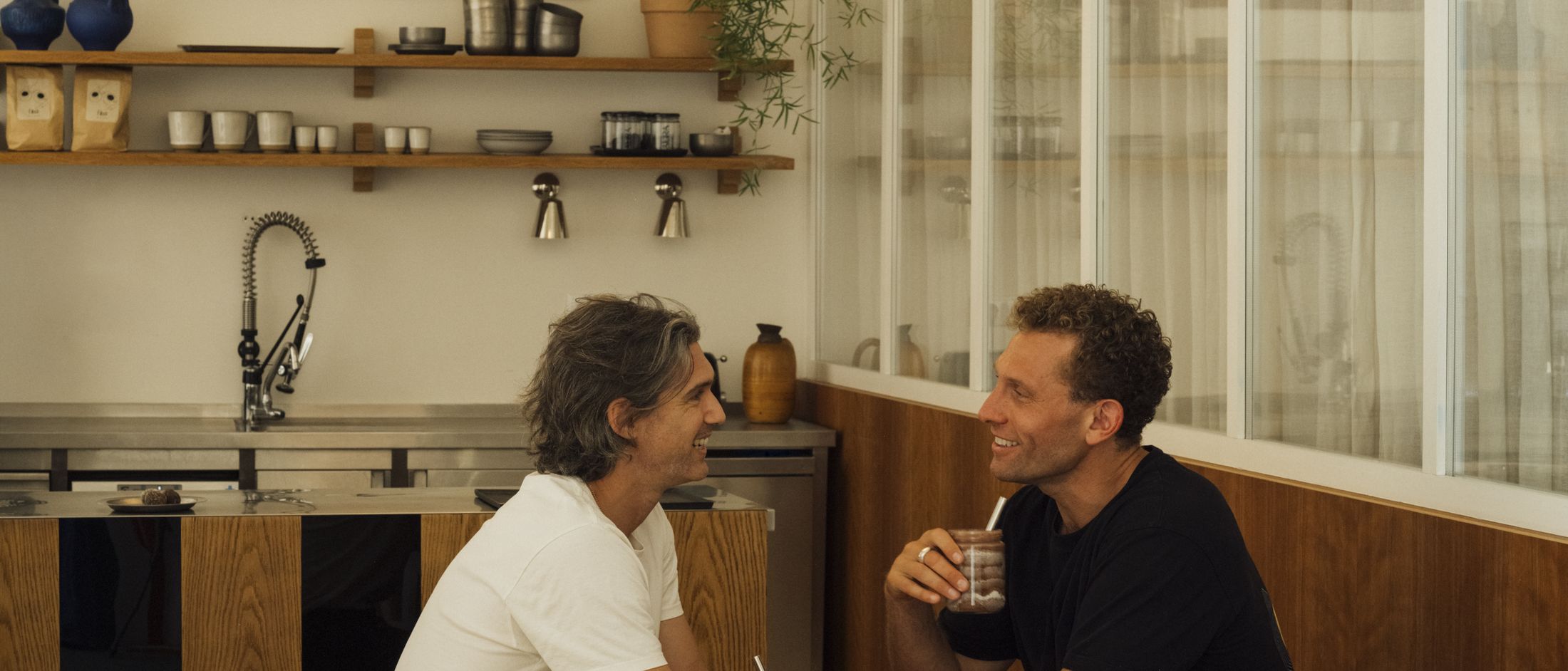 Two people talking over coffee at the café tables in MVMT Studio